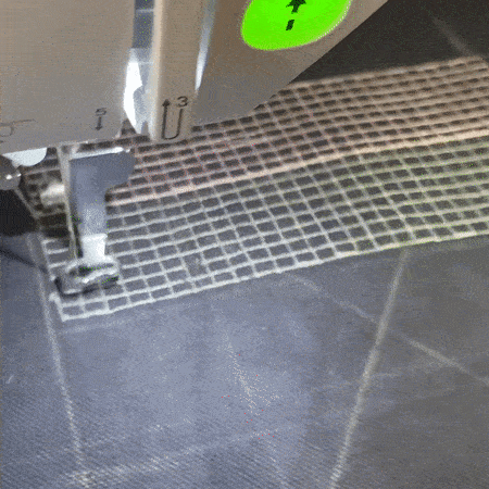 a gif of a machine embroidering a grid evenly
